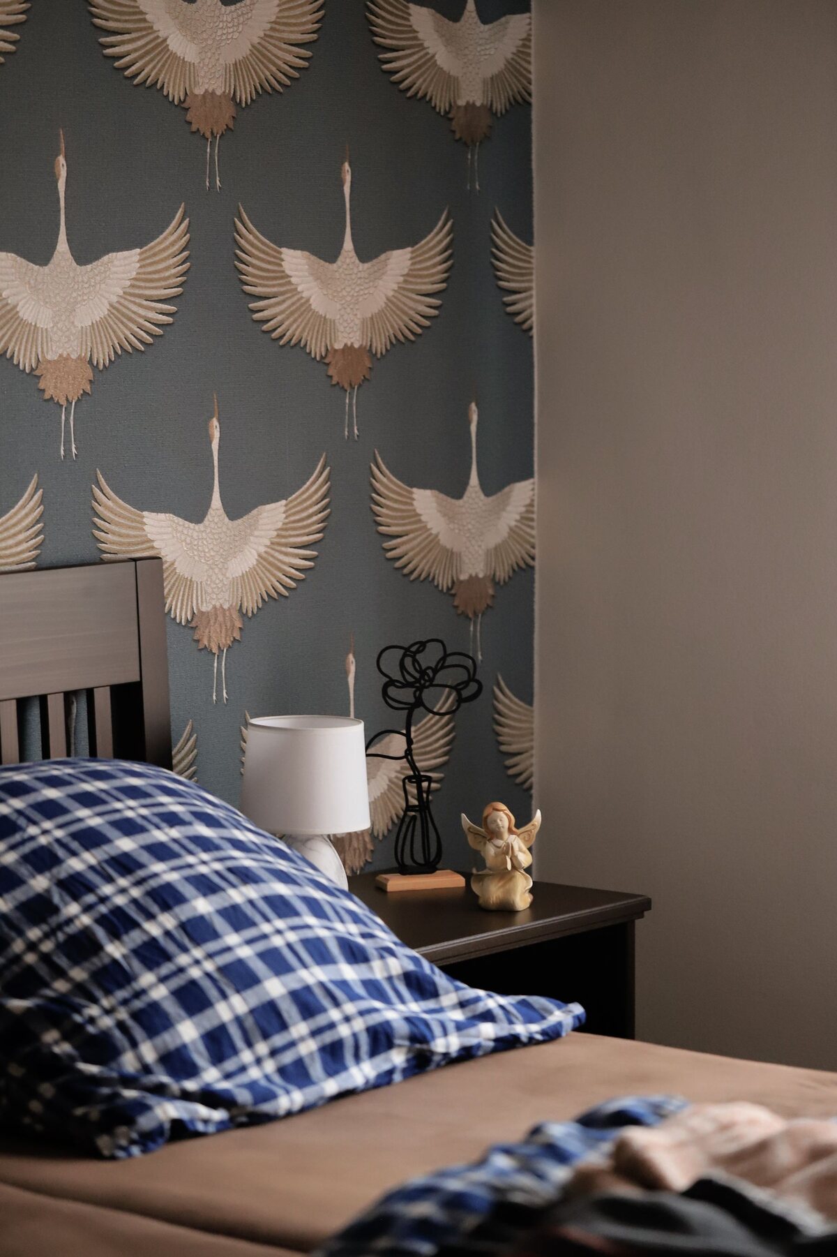 Bedroom accent wall in grey-blue chinoiserie crane wallpaper, precisely aligned from floor to ceiling